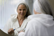 Mature woman looking in mirror