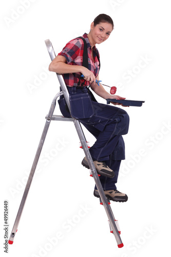 Photo: Woman sat on ladder with paint roller Woman sat on ladder with paint roller