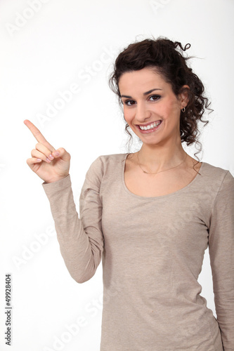 Photo: portrait of cute young woman all smiles pointing sideways portrait of cute young woman all smiles pointing sideways