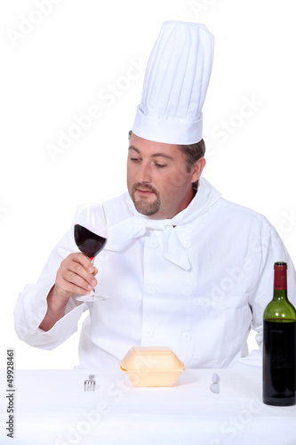 Photo: Chef with a glass of red wine and box of junk food Chef with a glass of red wine and box of junk food