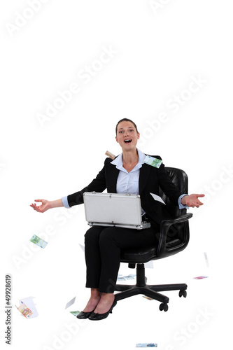 Photo: Overjoyed woman throwing money in the air Overjoyed woman throwing money in the air