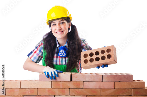 Photo: Woman builder with bricks on white Woman builder with bricks on white