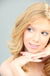 Blond woman alone on gray background
