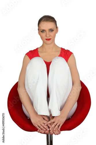 Photo: Blond woman sat in expensive designer chair Blond woman sat in expensive designer chair