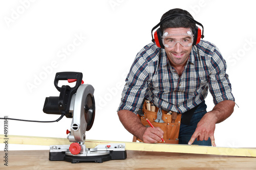 Photo: Man with band saw marking wood Man with band saw marking wood