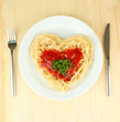 Cooked spaghetti carefully arranged in  heart shape and topped