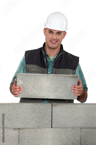 Photo: Tradesman placing a stone Tradesman placing a stone