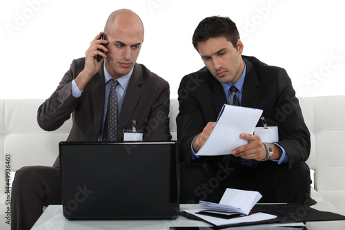 Photo: Two businessmen working together on project Two businessmen working together on project