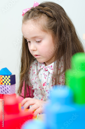 Photo: Little girl playing with building blocks Little girl playing with building blocks
