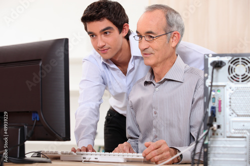 Photo: Computer technician helping office worker Computer technician helping office worker