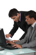 duo of male executives working on laptop