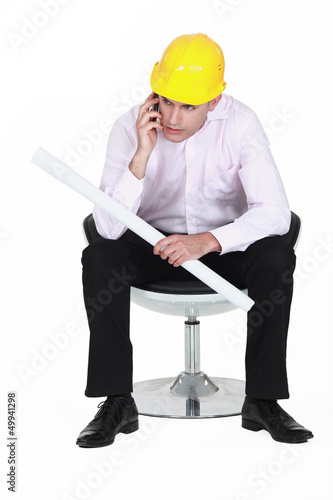 Photo: Architect holding plans and telephone Architect holding plans and telephone