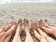 bare feet of a family on the shore