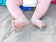 Photo: small feet with the diaper on the sand of the beach small feet with the diaper on the sand of the beach