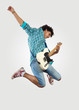 Photo: young man playing on electro guitar and jumping young man playing on electro guitar and jumping