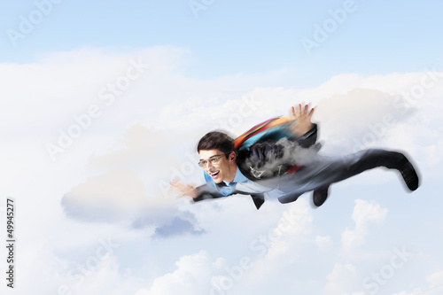Photo: Young businessman flying with parachute on back Young businessman flying with parachute on back