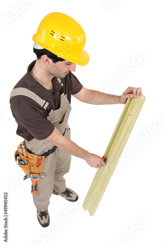 Photo: Carpenter measuring plank of wood Carpenter measuring plank of wood