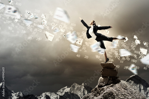 Photo: businesswoman standing atop of mountain businesswoman standing atop of mountain