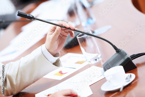 Photo: Hands of businessman holding microphone Hands of businessman holding microphone