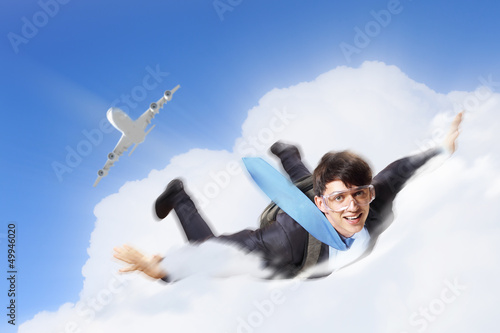 Photo: Young businessman flying with parachute on back Young businessman flying with parachute on back