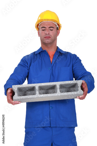 Photo: Builder carrying heavy building block Builder carrying heavy building block