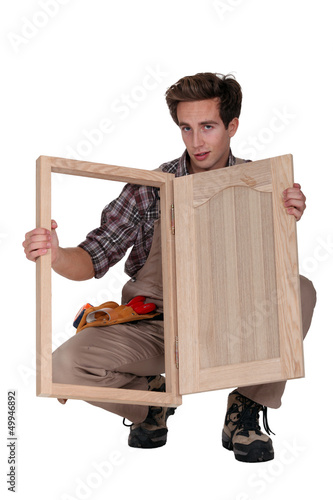 Photo: Carpenter displaying a wooden shutter Carpenter displaying a wooden shutter