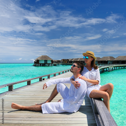 Photo: Couple on a beach jetty at Maldives Couple on a beach jetty at Maldives
