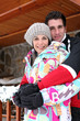 Photo: Couple hugging by their winter chalet Couple hugging by their winter chalet