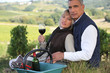 Farmer and wife drinking wine in a vineyard