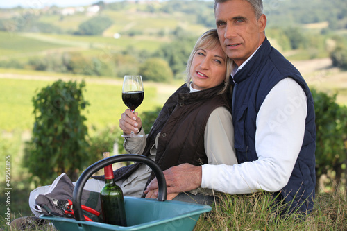 Photo: Farmer and wife drinking wine in a vineyard Farmer and wife drinking wine in a vineyard