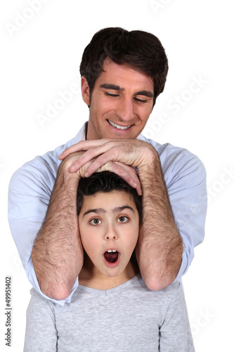 Photo: Man laying his arms over a surprised girl's head Man laying his arms over a surprised girl's head