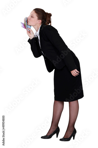 Photo: Businesswoman kissing money Businesswoman kissing money