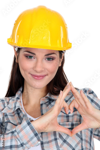 Photo: young craftswoman making a hearth sign with her hands young craftswoman making a hearth sign with her hands