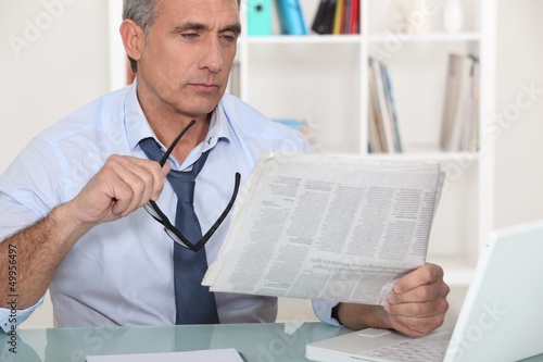 Photo: businessman reading the newspaper businessman reading the newspaper