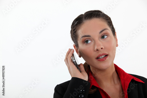 Photo: woman with cell phone straining her ears woman with cell phone straining her ears