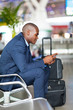 african businessman using cell phone at airport