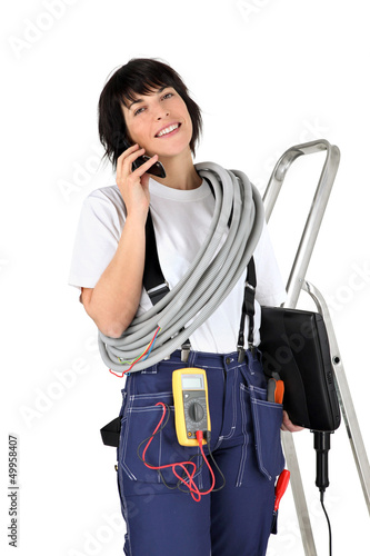 Photo: Female electrician making telephone call Female electrician making telephone call