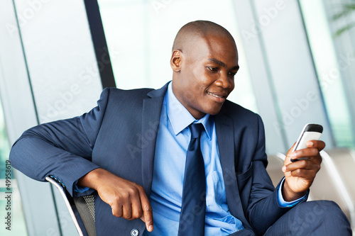Photo: handsome african american businessman using smart phone emailing handsome african american businessman using smart phone emailing