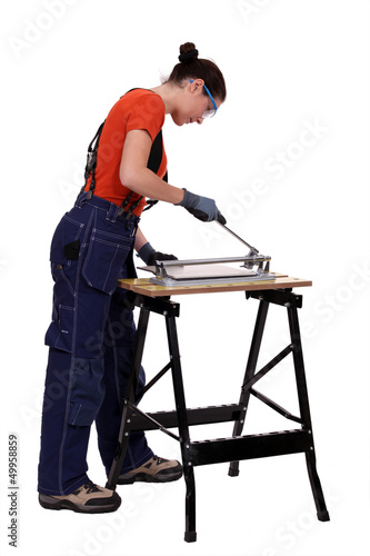 Photo: Woman cutting tile Woman cutting tile