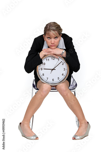 Photo: Businesswoman sitting with a large clock Businesswoman sitting with a large clock