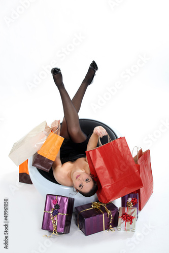 Photo: Woman in chair holding shopping bags Woman in chair holding shopping bags