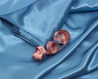 Pink tape-measure on blue silk background