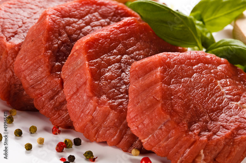 Photo: Raw beef and vegetables on white background Raw beef and vegetables on white background