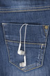Earphones hanging out of jeans pocket