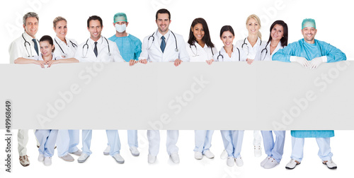 Photo: Group of doctors presenting empty banner Group of doctors presenting empty banner