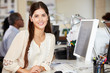 Photo: Woman Working At Desk In Busy Creative Office Woman Working At Desk In Busy Creative Office