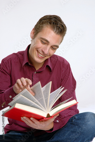 Photo: Hombre joven leyendo un libro.Estudiante universitario. Hombre joven leyendo un libro.Estudiante universitario.