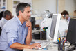 Man Working At Desk In Busy Creative Office