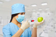 Chemist with syringe and apple