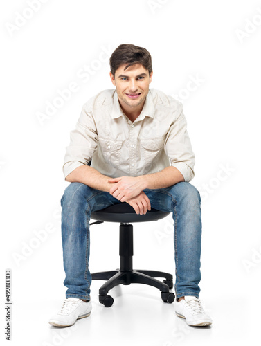 Photo: Portrait of smiling happy man sits on office chair Portrait of smiling happy man sits on office chair